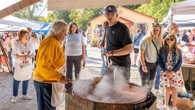 Steven Freund of Arnold stirs the apple butter and Nadine Garland of Herculaneum assists.