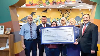 Missouri Secretary of State Jay Ashcroft, right, presents a check for $20,000 from the American Rescue Plan Act of 2021 to library official