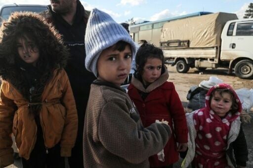 Kurdish children and their families fleeing a government advance arrive in Qamishli
