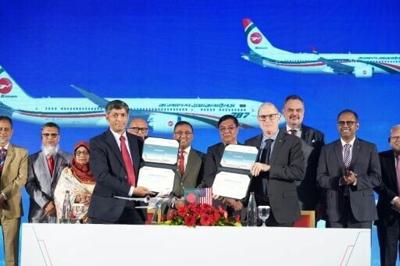 Biman Bangladesh Airlines CEO Kaizer Sohel Ahmed (L) and Boeing Vice President Paul Righi (R) exchange signed documents after signing the deal