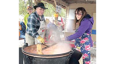 Kimmswick Historical Society members Greg Pfeiffer, left, and Darlene Desroches stir a pot of apple butter at last year’s festival.