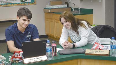 Connor Kisner, left, and Ashlynn Jones confer before a recent meeting of the De Soto Board of Education.