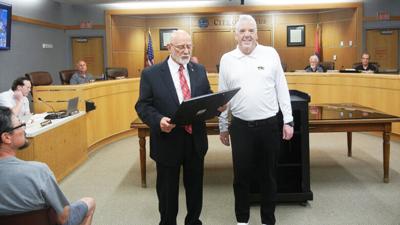 Festus Mayor Sam Richards, left, presents a proclamation to Festus R-6 Superintendent Link Lutrell.