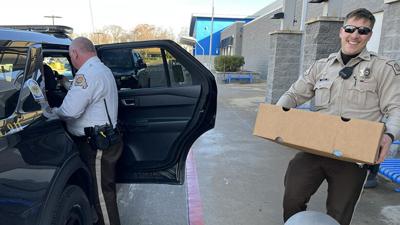 Jefferson County Sheriff’s Office deputies load a car with turkeys donated by Chuck Gerding with Gerding Enterprises for area first responders.