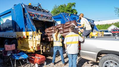 Waste Connection employees push a couch into a truck during the Festus Spring Clean Up day.