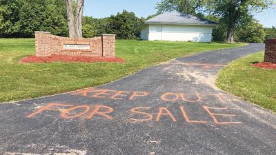 One of the three entrances to St. John Cemetery was spray-painted with “KEEP OUT FOR SALE” on the pavement.