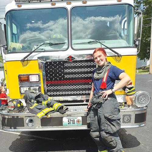 Firefighter Riley Coleman poses by the firetruck during an event last summer.
