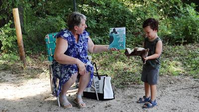 Brenda Smith, a Jefferson County Library children’s librarian, reads to Luca Saputo, 3, of Festus at the Joachim Loop Trail in Herculaneum, where a Story Walk was recently installed.