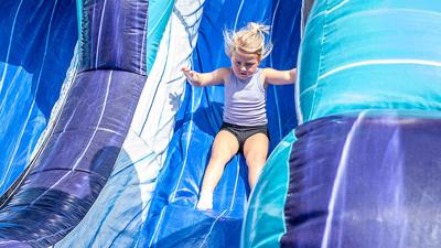 Lakelynn Sample, 3, of De Soto rides the inflatable slide Sept. 19 during the  De Soto Fall Festival.