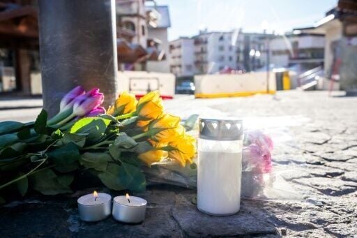 Flowers left near Le Constellation bar in Switzerland, where a fire is believed to have killed dozens