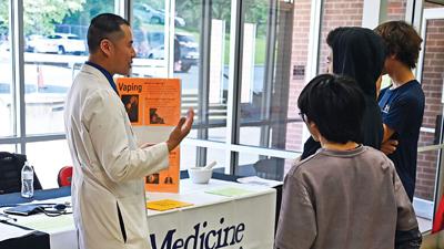 Jason Wang speaks with students at the 2026 Senn-Thomas Middle School Career Expo.