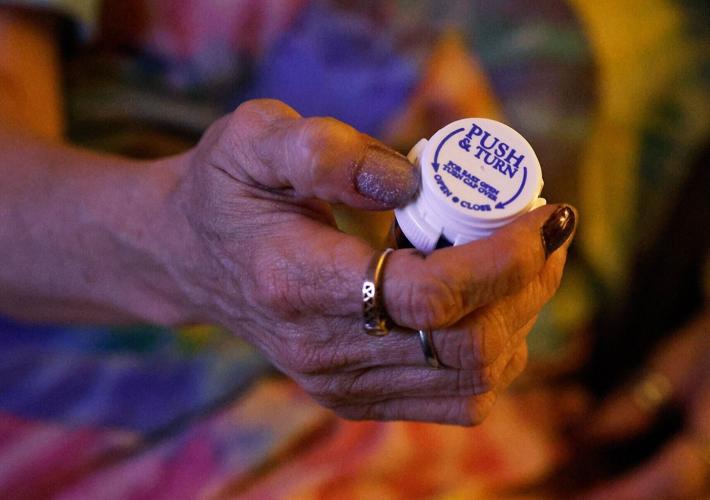 Sonia Staires inspects a bottle of her mother’s medication