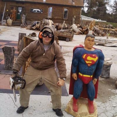 Ryan Meyer stands next to a Superman he carved in 2005.