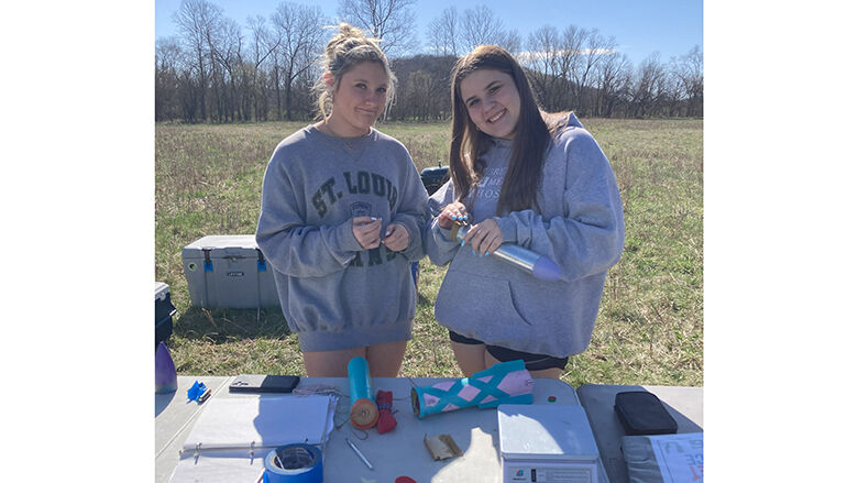 Fox High School rocketry team members Heidi Brockmann, left, and Paige Metcalf work on one of the team’s rockets.