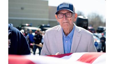 Vernon Wilke, a World War II veteran and Battle of the Bulge survivor, helps raise the American flag during the new flagpole dedication ceremony March 14 at the Arnold VFW Post 2593.