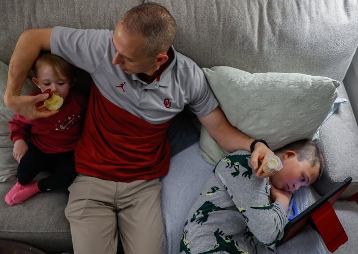 Tom, Carter’s dad, center, shares his apple with Lena, Carter’s sister