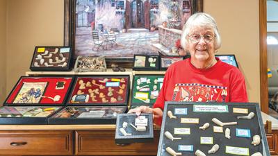 Kathie Roussin of De Soto holds display cases of colonial clay pipes.