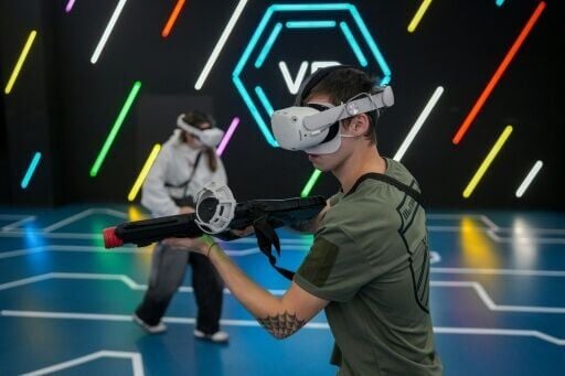 A boy and his girlfriend play a virtual reality shooter game in a Kharkiv shopping centre