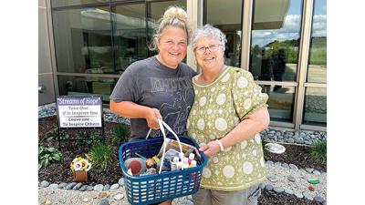Jan Bass, right, a patient at the Cancer Center, and her daughter-in-law, Amee DiLorenzo, hold their basket of painting supplies. They just finished one of Jan’s infusion sessions, during which they painted several rocks for the garden.