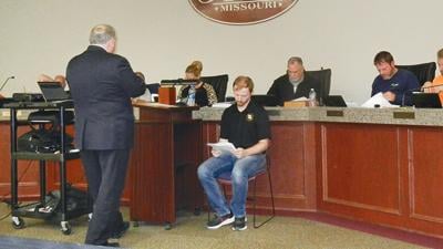 Jay Kanzler, attorney for Pevely Hospitality Group, standing, cross examines Adam Mitchell, Pevely building official, during the hearing.