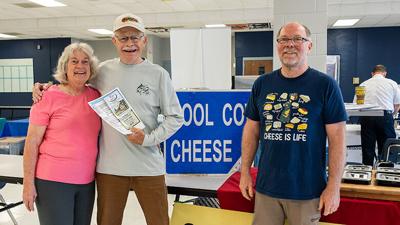 Mike Cruse, with wife, Peggy, of Cedar Hill wins the grand prize. Pictured with him is Tom Blatchford of Cool Cow Cheese in Owensville.