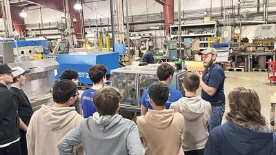 Dave Urban, mechanical and manufacturing engineer with Buckert Mold and Machine Co., gives Woodridge Middle School students a tour of the facility.