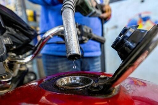 A worker fills the tank of a motorcycle at a petrol station in Giza, Egypt, on March 10, 2026