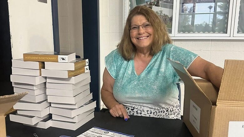 Optimist Alicia Cummiskey prepares dictionaries for delivery.