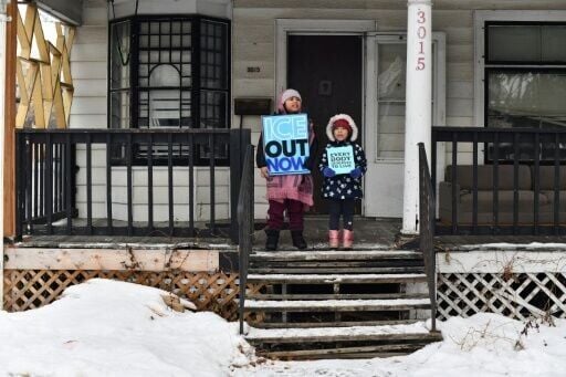 Children hold signs along the route of the protest march in Minneapolis