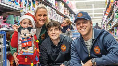 Brayden Miller, 4, from the Jefferson R-7 area, with Antonia firefighters, from left, Christi Weidler, Caleb Shannon and Ethan Stulce at Jeffco Shop with a Cop.