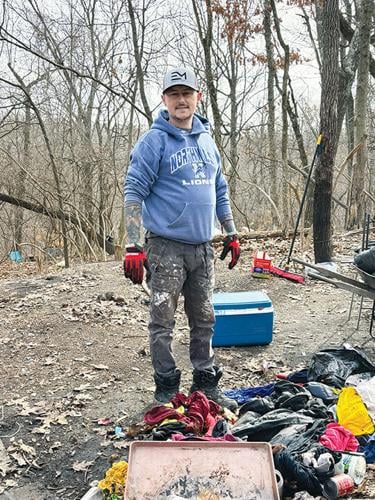 Rob Brummel, who has volunteered at the High Ridge encampment since last July, cleans the grounds.
