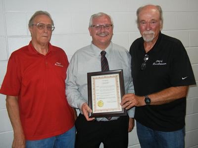 City Administrator Jim Kasten, right, hands Dunklin R-5 Superintendent Clint Freeman, center, a proclamation recognizing him as the September Citizen of the Month. They are joined by Herculaneum Mayor Bill Haggard.