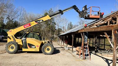 Metal fabrication students dismantle a wooden structure on the Jefferson College campus to make way for an outdoor fire science training site.