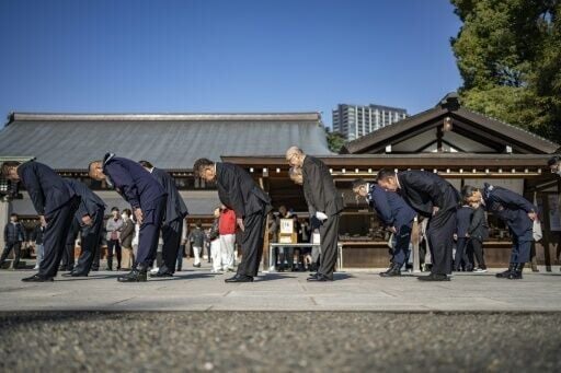 Members of the ultra-nationalist group Taikosha bow during a prayer ritual at Yasukuni shrine on the 84th anniversary of Japan's Pearl Harbour attack