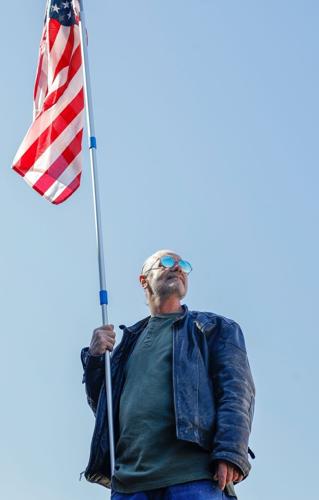 Tracy King holds the flag during the No Kings rally