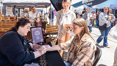Allison Roscow, 9, of Festus and her friend, Scarlett Selby, 8, of Festus pick out a free crystal from one of the vendors at the Festus Main Street Association Art & Music Festival.