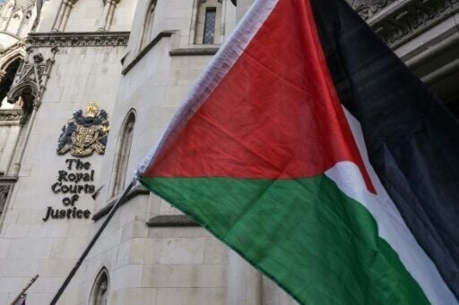 A Palestinian flag held up by protesters outside the London appeal court where the Palestine Action case is being heard