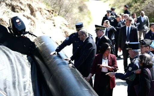 Nunez and Mahmood inspect a dinghy on a beach near the northern French village of Zuydcoote