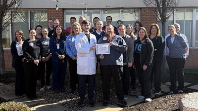 Dr. Marshall Kirsch, stroke medical director, and Josh Ennis, stroke program coordinator, hold the new certificate in front of members of various units from across Jefferson Mercy that support stroke care.