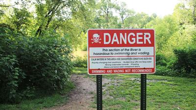 A sign at Cedar Hill Park warns people about the dangers of swimming in the Big River there.