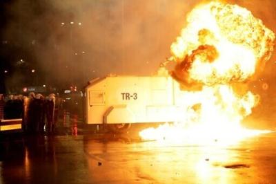 A petrol bomb explodes next to a police vehicle outside parliament in the latest opposition protest in the Albanian capital