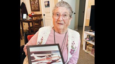 Marlis Thum with a photo of the Cessna single-engine plane she owned and flew.
