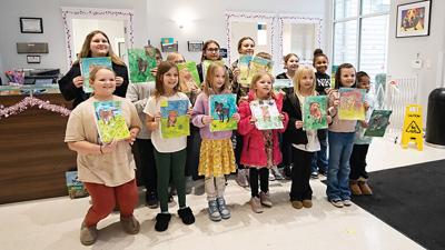 Students from House Springs Elementary School show off their paintings of adoptable dogs at the Jefferson County Animal Resource Center in House Springs on Feb.5.