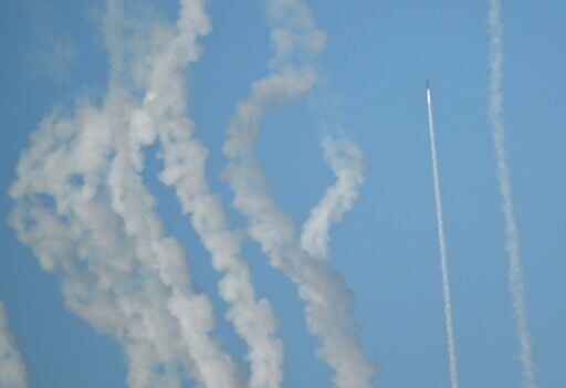 A rocket and plumes of smoke are seen in the sky above Pingtan as the Chinese People's Liberation Army conduct military drills