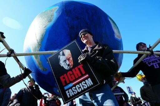 A protester in Washington holds a sign that compares US President Donald Trump to Nazi leader Adolf Hitler