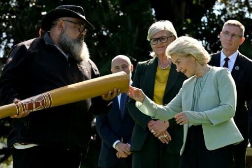 European Commission President Ursula von der Leyen (2nd R) examines a didgeridoo with Australia's Governor-General Sam Mostyn (C) during a traditional Aboriginal welcome ceremony at Admiralty House in Sydney