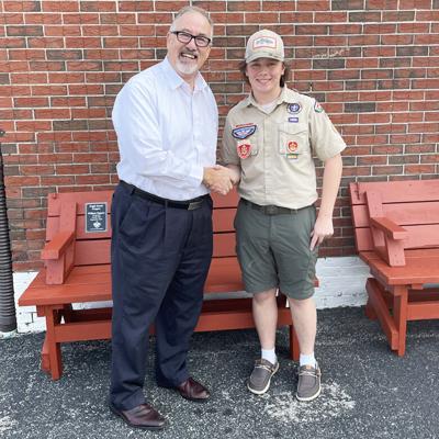 Jefferson County Salvation Army director Larry Hostetler, left, and Boy Scout William Pagano with two of the benches the boy made for his Eagle Scout project