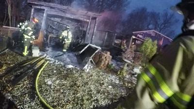 Firefighters work to extinguish a fire that destroyed a shed and pergola at this home on Ridgeview Drive was destroyed by fire.