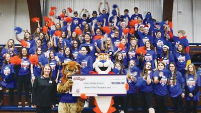 Kellogg’s mascot Tony the Tiger presents a check for $29,000 to Valley Middle School to buy new fitness equipment for its physical education and fitness classes.