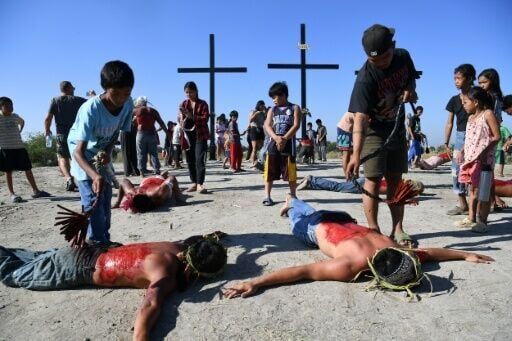 Penitents prostrate themselves as companions flagellate their backs in front of crosses prior to the annual crucifixion ritual in the Philippines